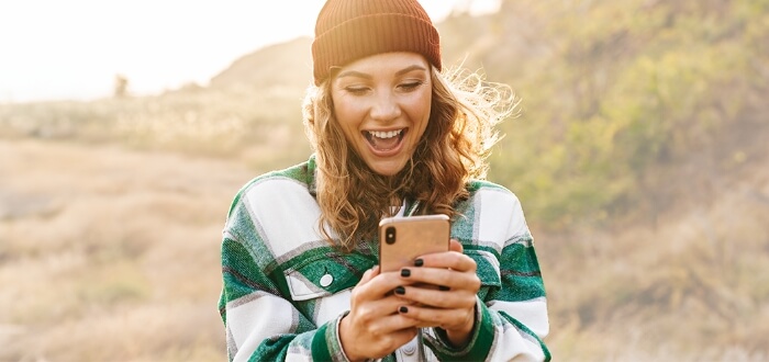 A traveling woman with her smart phone powered by Spectrum Mobile.